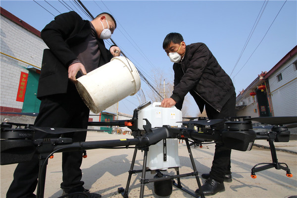 중국 허베이성 한단시 청완 마을에서 의료요원들이 드론 탱크에 소독제를 주입하고 있다.사진=차이나데일리