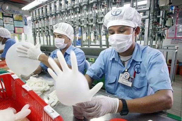 말레이시아 고무장갑 공장에서 직원들이 제품을 검사하고 있다. 사진=더스타