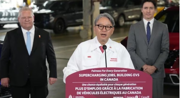 미베 도시히로 일본 혼다 자동차 최고경영자(CEO)가 25일 캐나다 온타리오주 앨리지스톤의 혼다 공장에서 쥐스뗑 트뤼도 총리(오른쪽)와 더그 포드 온타리오주 총리가 지켜보는 가운데 150억 캐나다달러 규모의 투자계획을 발표하고 있다.사진=캐나디언프레스