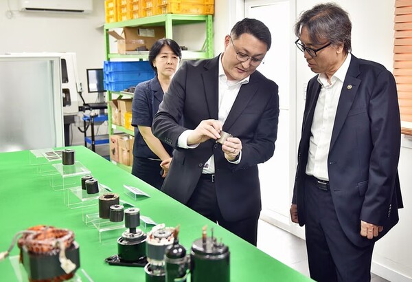LG전자가 폐가전의 컴프레서 폐기 단계에서 핵심 광물인 희토류 영구자석을 회수해 재활용하는 '폐가전 냉매압축기(컴프레서) 폐영구자석 회수 시범사업' MOU를 맺은 27일 LG전자 담당자(가운데)가 기후에너지환경부 금한승 제1차관(오른쪽)에게 컴프레서 내부에 포함된 영구자석에 대해 설명하고 있다. 사진=LG전자